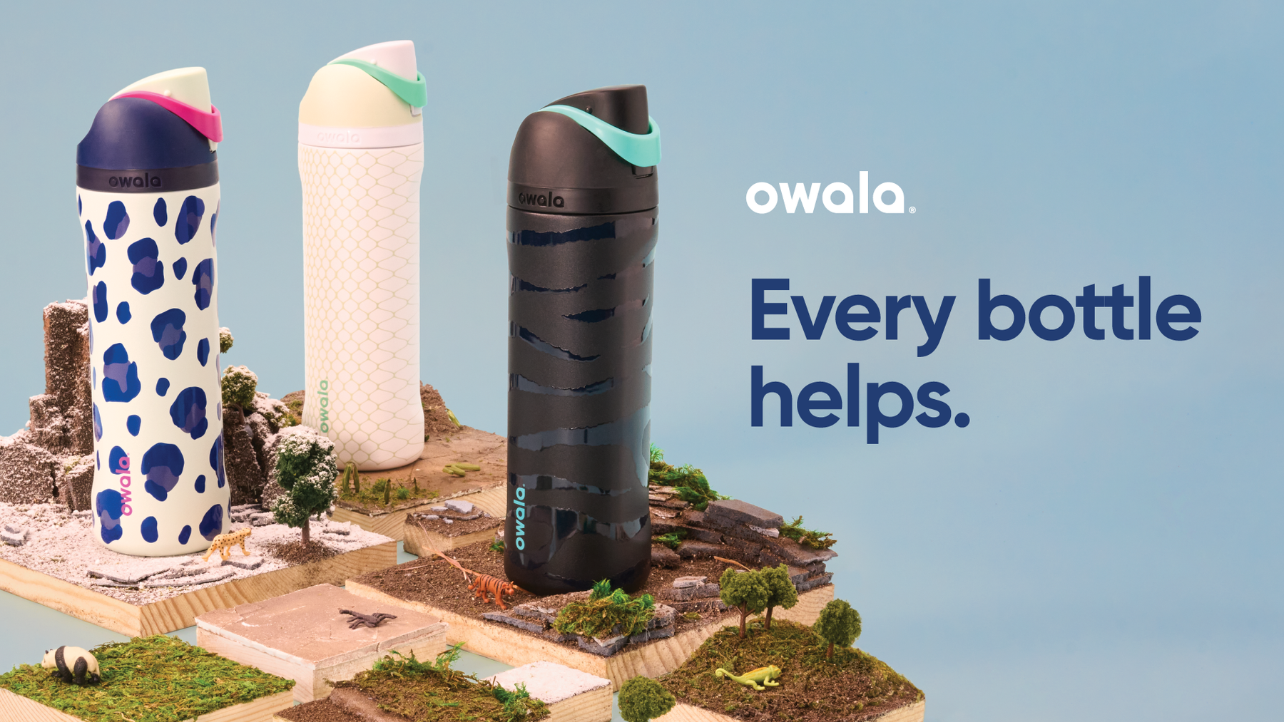 Animal-themed Owala bottles sitting on environment dioramas