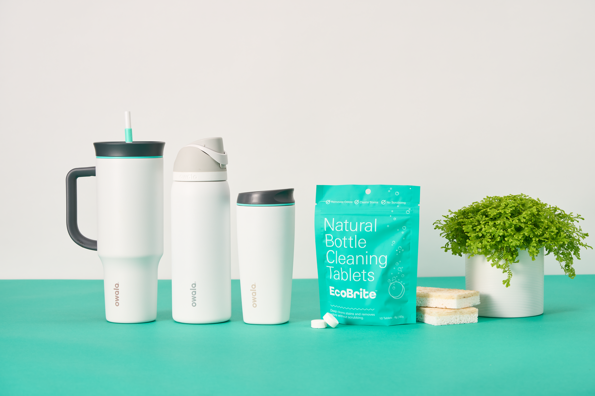 Lineup of Owala 40oz Tumbler, 32oz Freesip, and SmoothSip Slider water bottles, featuring Ecobrite "Natural Bottle Cleaning Tablets" against a colorblock background.