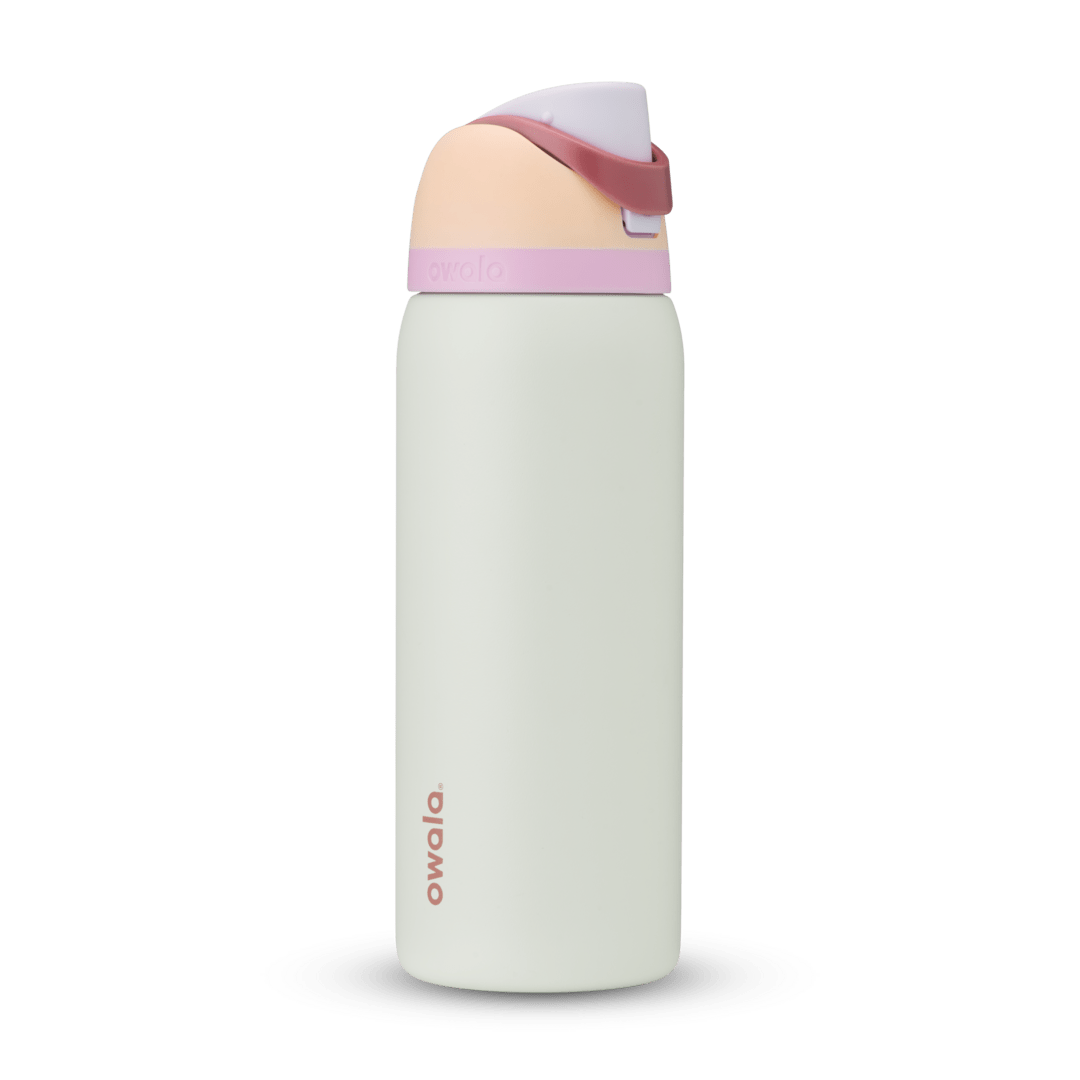 FreeSip 32oz in Coastal Mist, pale mint green body with peach flip cap, dusty rose carry loop, lavender accent band, and pink logo